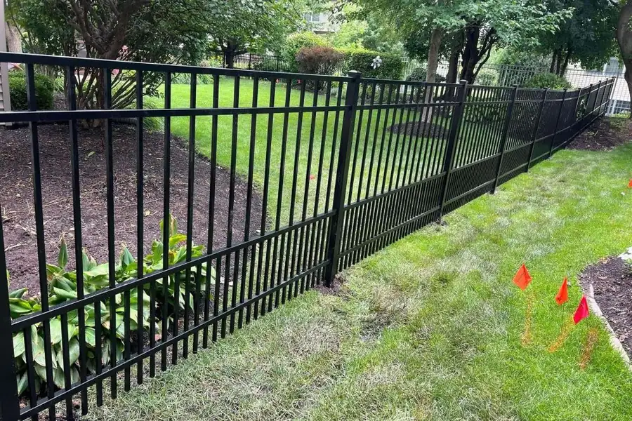 Ornamental aluminum fence running across a graded estate yard