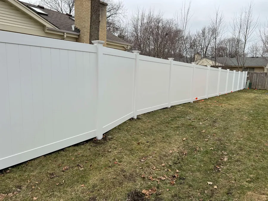 White vinyl privacy fence installed along a residential yard