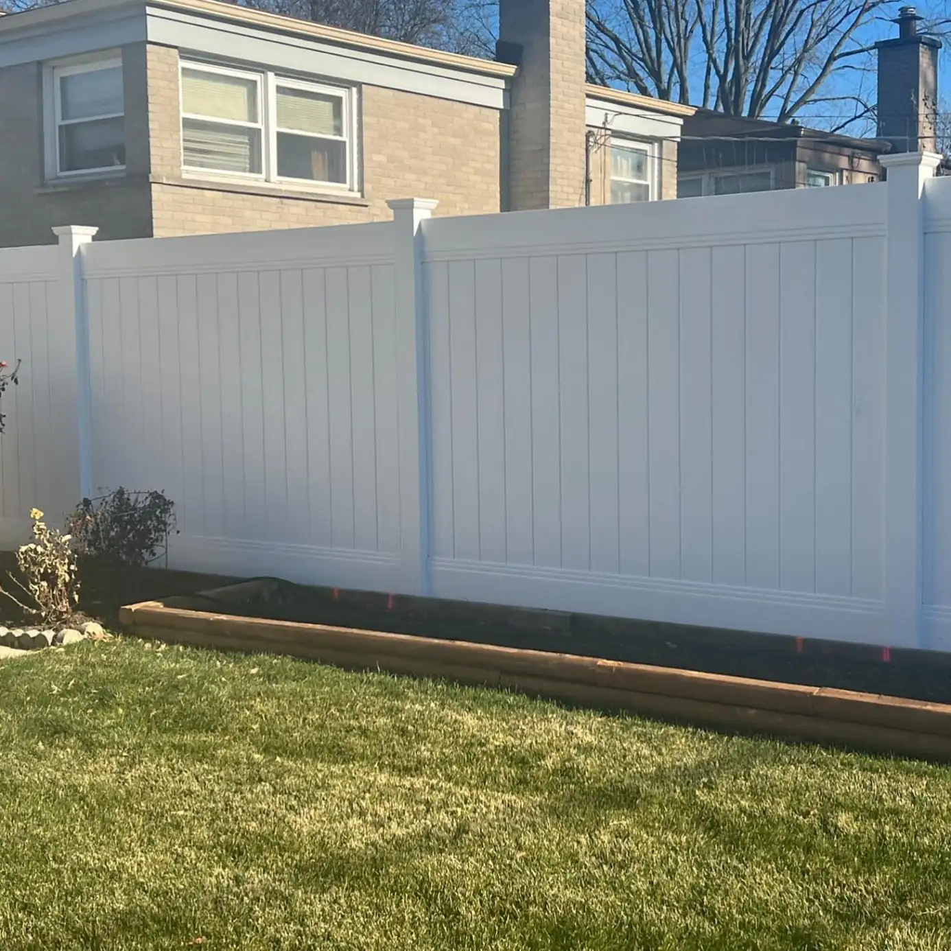 White vinyl privacy fence installed along a back yard property line at an Aurora, IL home